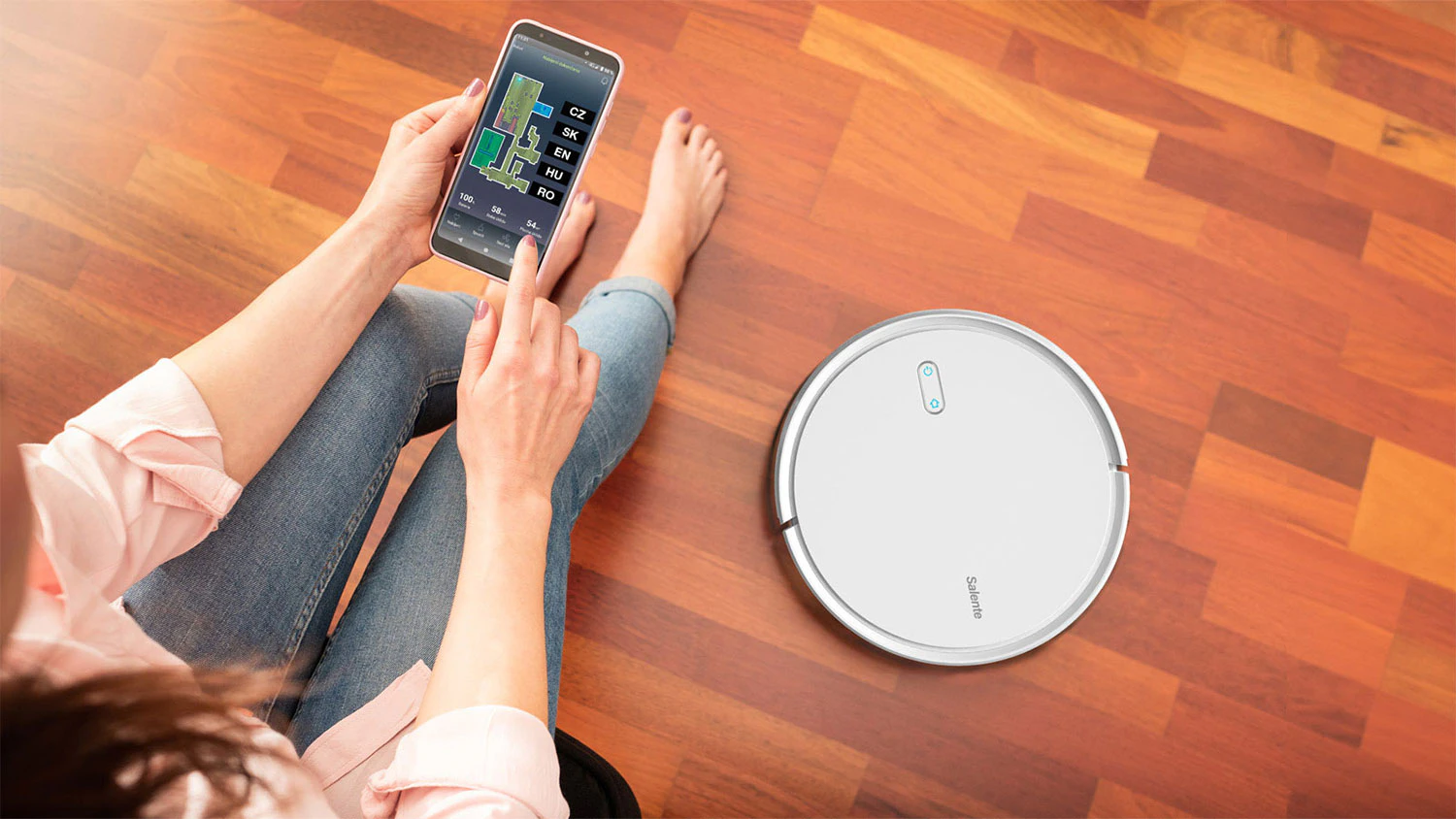 Žena ovl&aacute;daj&iacute;c&iacute; robotick&yacute; vysavač Salente G4 pomoc&iacute; aplikace