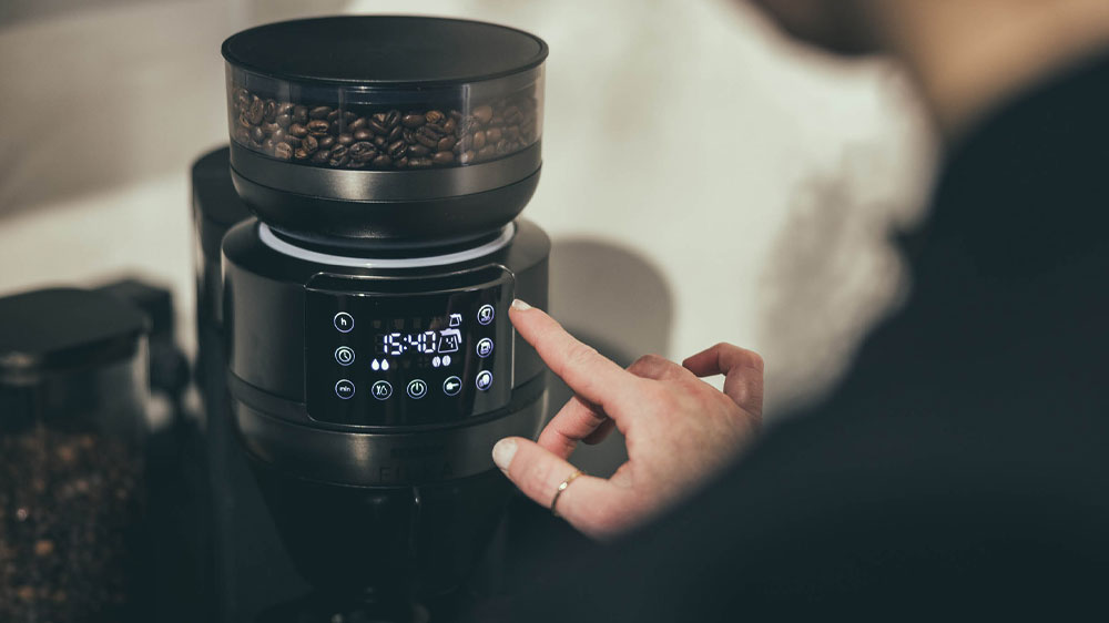Mužská ruka ovládající automatický kávovar na filtrovanou kávu Severin FILKA Dark Inox KA 4849 pomocí LED dotykového displeje_03