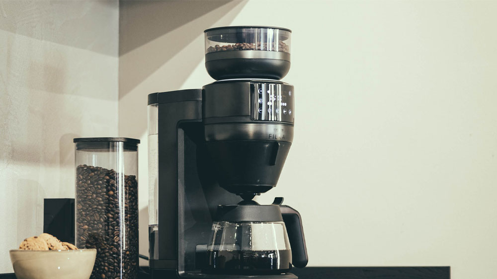 Automatický kávovar na filtrovanou kávu Severin FILKA Dark Inox KA 4849 na lince s dózou kávových zrn vedle něj_04