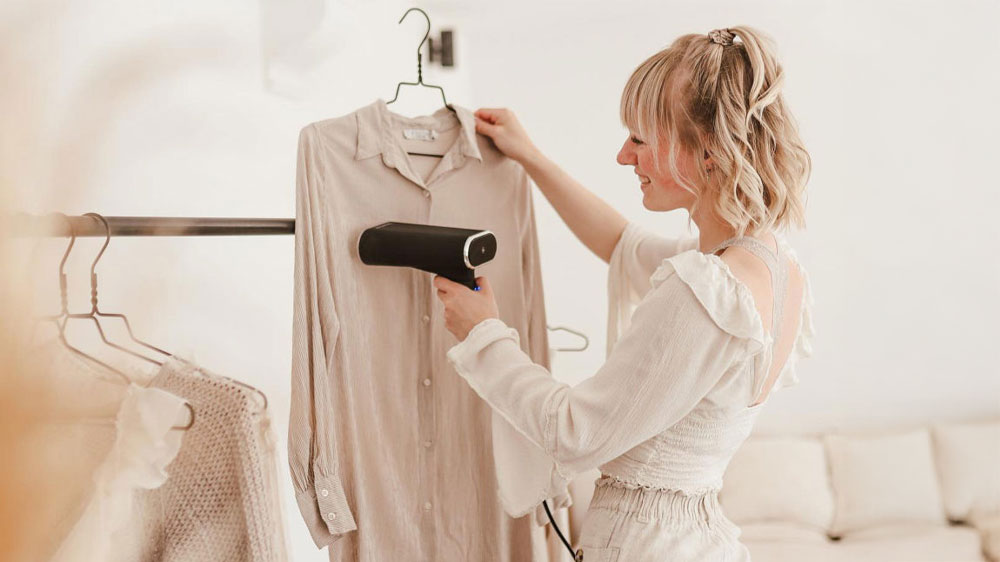 Žena napařuje košili ručním napařovačem oděvů SteamOne JAMES V2_02