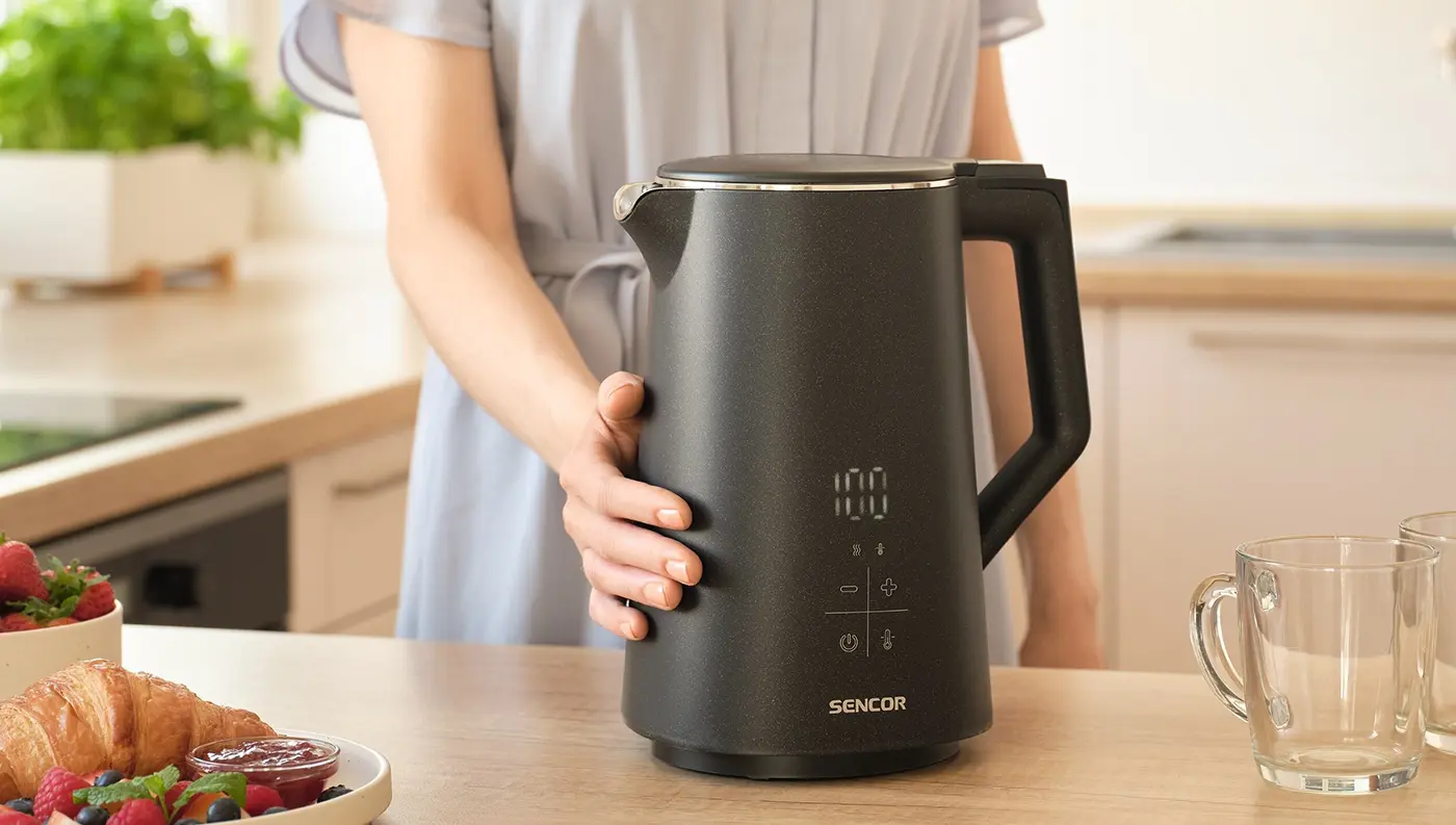 Žena sa dotýka dvojstennej rýchlovarnej kanvice Sencor SWK 0600BK