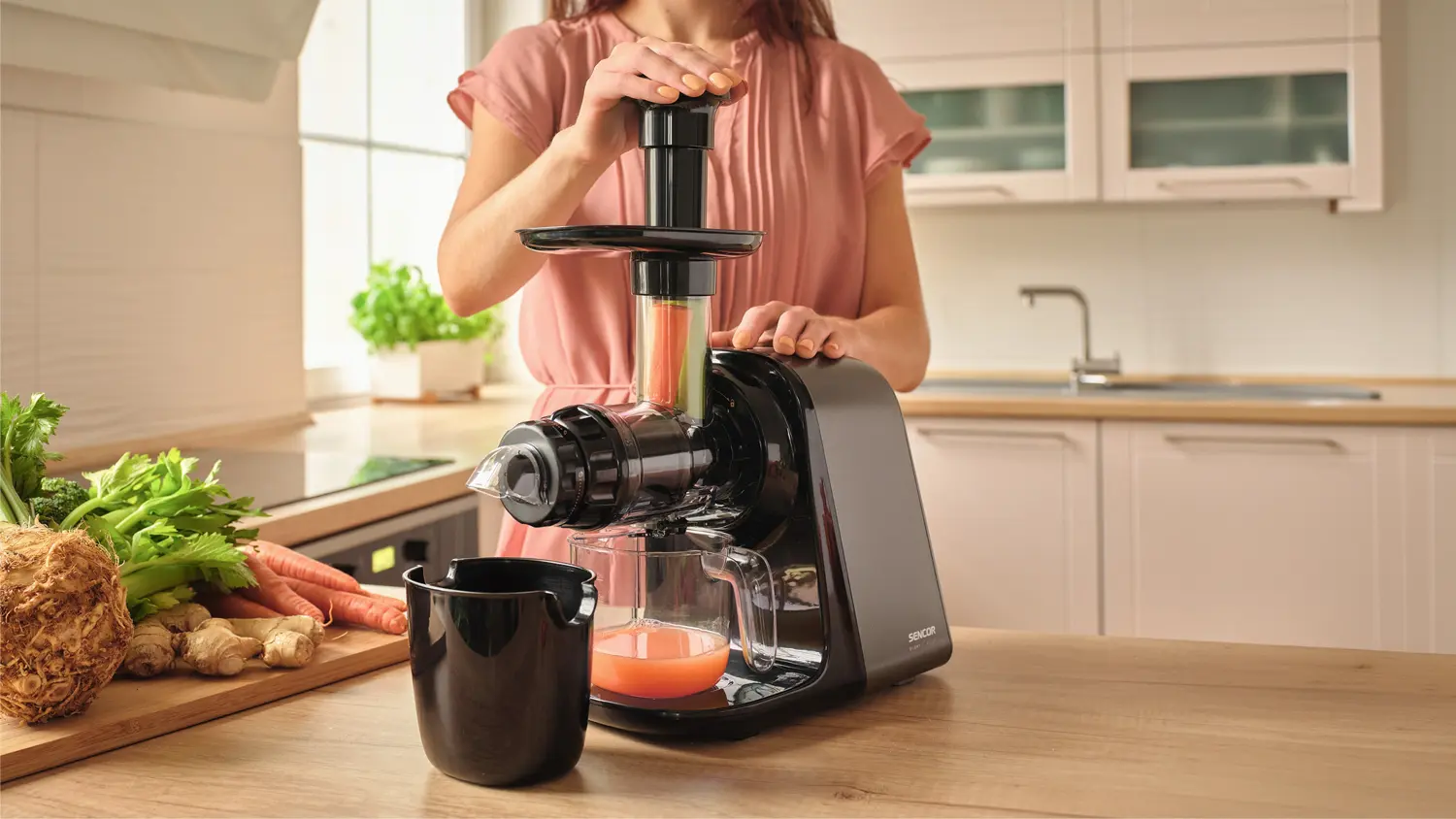 Žena mačk&aacute; &scaron;ť&aacute;vu přes &scaron;nekov&yacute; od&scaron;ťavňovač Sencor SSJ 0900BK
