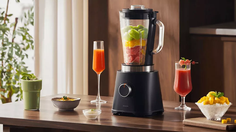 Stolný mixér Xiaomi Blender EÚ naplnený ovocím a vedľa hotovej drinky a miska s ovocím_03