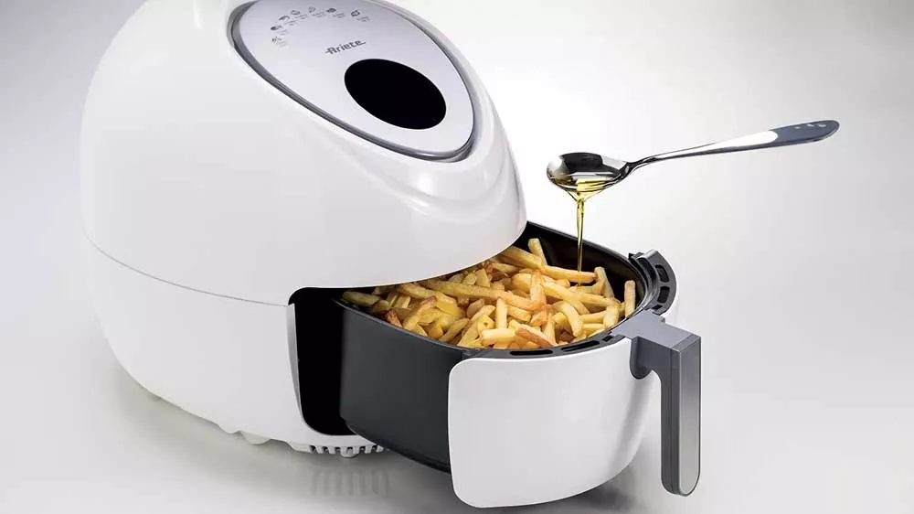 Horkovzdu&scaron;n&aacute; frit&eacute;za Ariete 4618/03 naplněn&aacute; hranolkami pol&eacute;van&yacute;mi lžičkou oleje_02