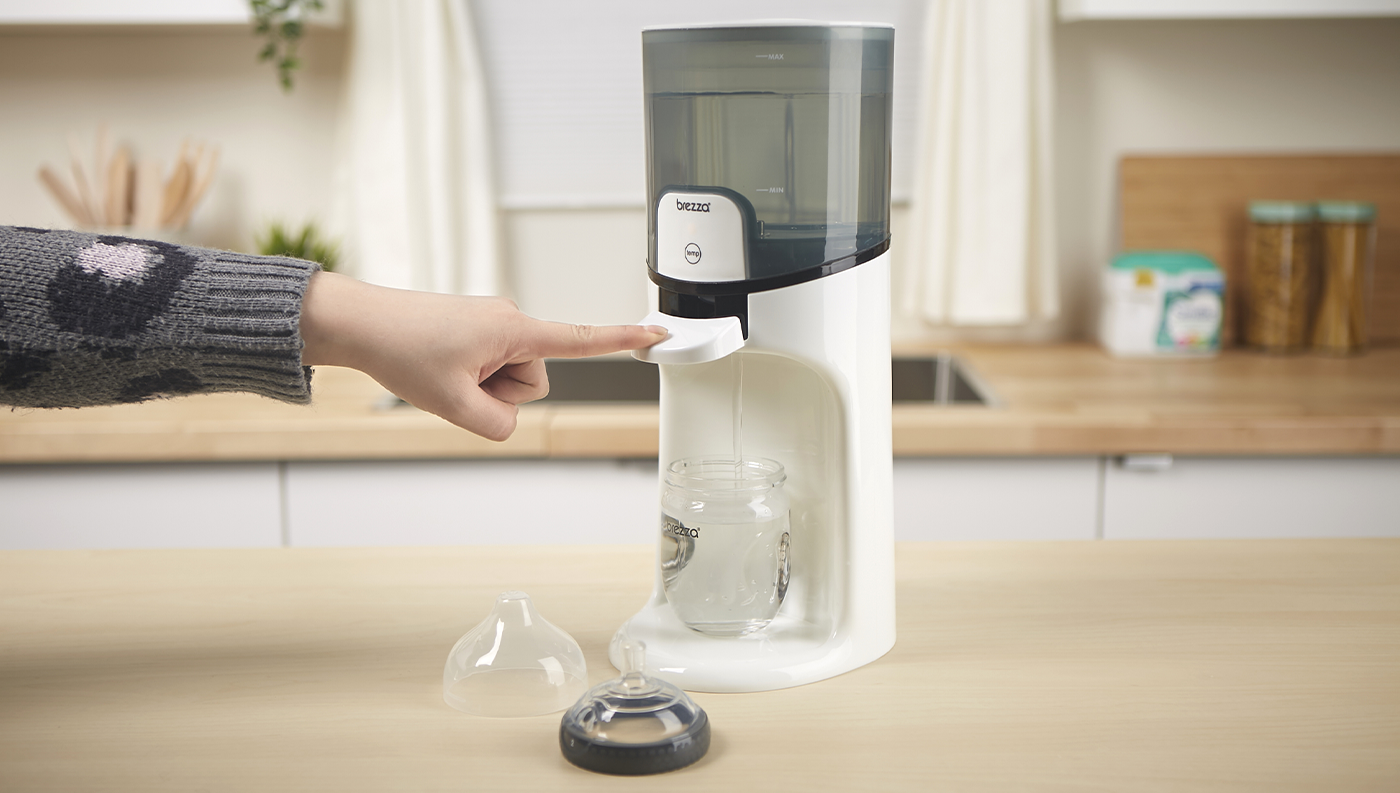 Dítě mačkající nalévací páčku u ohřívače Baby Brezza BRZ0057 Instant Warmer