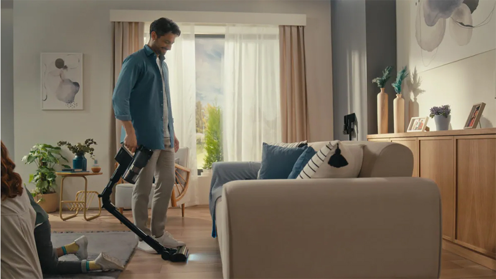 Muž vysává tyčovým vysavačem_02