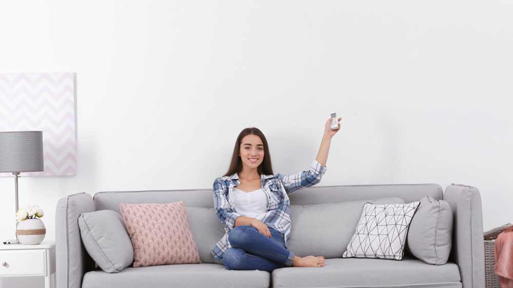 Žena na gauči s d&aacute;lkov&yacute;m ovladačem v ruce_03