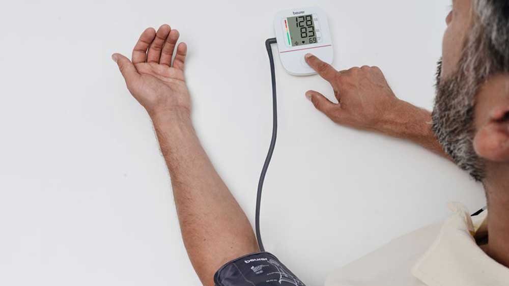 Muž si kontrolu tlak pomocí pažního tlakoměru Beurer BM 23_02