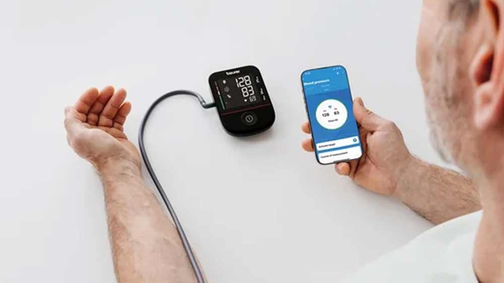 Muž se měří pažním tlakoměr Beurer BM 48 a výsledky přenáší do aplikace_02
