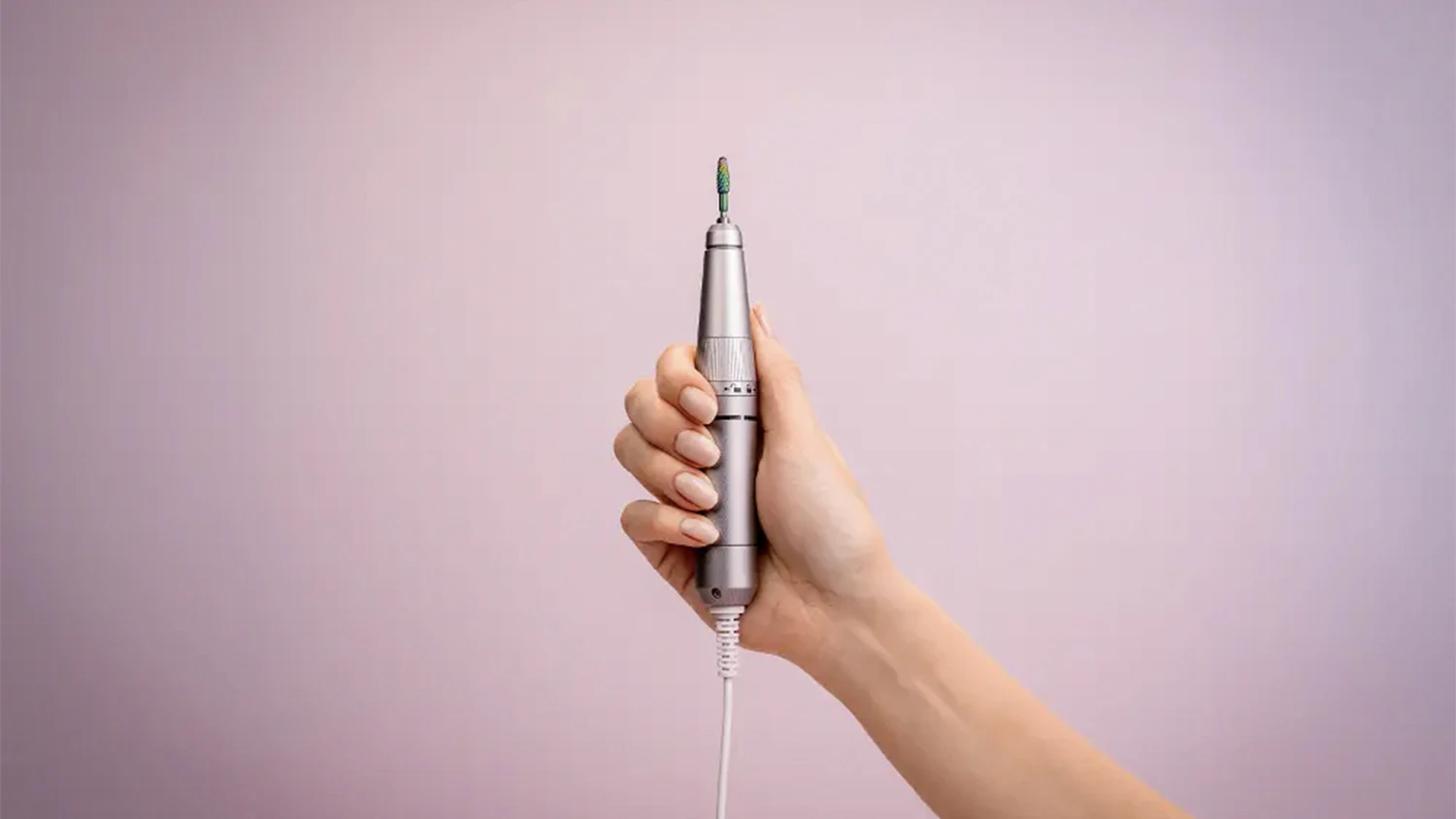Žensk&aacute; ruka drž&iacute; elektrick&yacute; piln&iacute;k na nechty zo sady na manik&uacute;ru a pedik&uacute;ru Beurer MP 200 StudioNails Pro