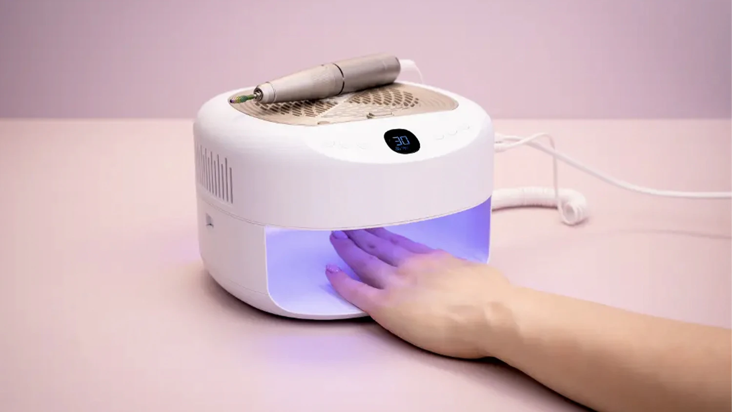 Žensk&aacute; ruka pod LED UV lampou zo sady na manik&uacute;ru a pedik&uacute;ru značky Beurer