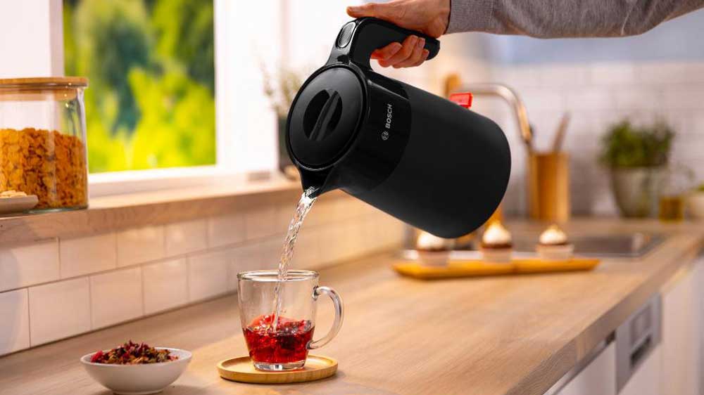 Ruka zalévající šálek s čajem vodou z rychlovarné konvice Bosch TWK2M163 MyMoment_02