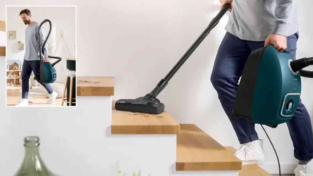 Muž vysává schody vysavačem Bosch BGL41FAM1H ProFamily, modrý_03