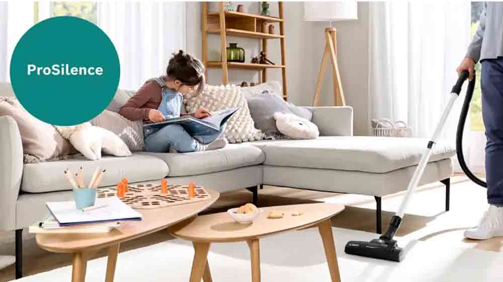 Holčička si čte na gauči a muž vysává s vysavačem Bosch_02