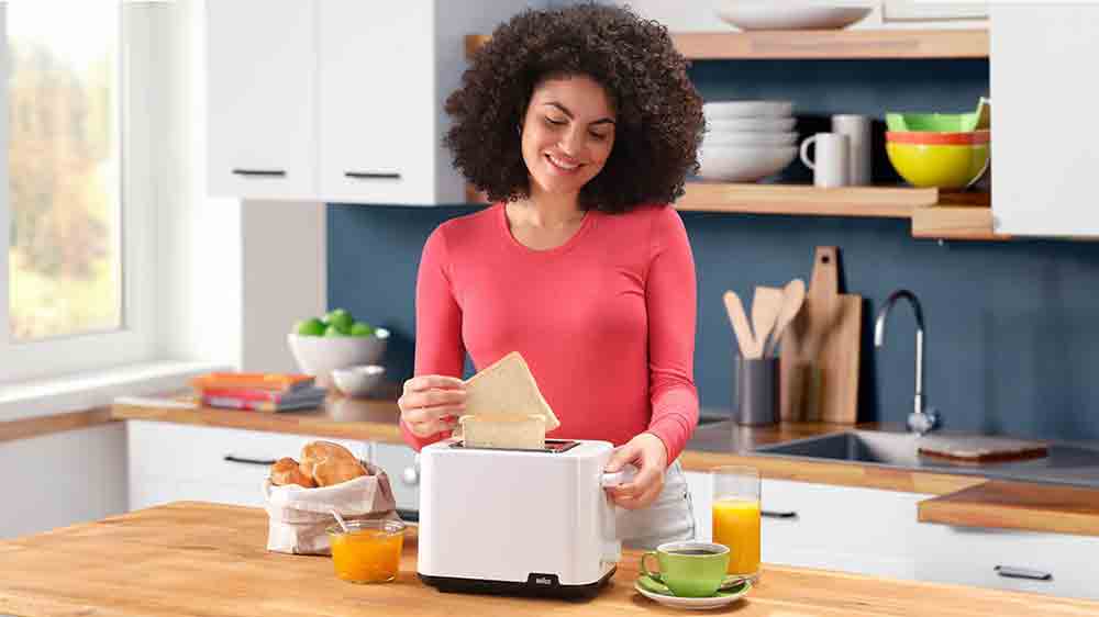 Žena připravuj&iacute;c&iacute; sn&iacute;dani na topinkovači Braun Breakfast 1 HT1010.WH