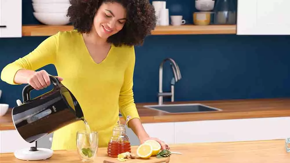 Žena připravuj&iacute;c&iacute; čaj s konvic&iacute; Braun Breakfast 1 WK110.BK