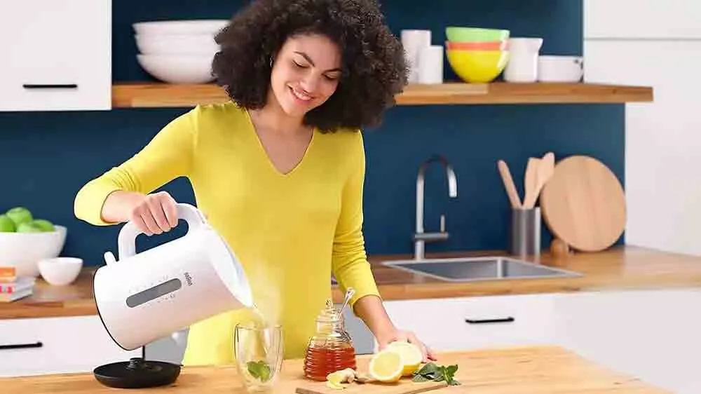 Žena připravuj&iacute;c&iacute; čaj s konvic&iacute; Braun Breakfast 1 WK110.BK