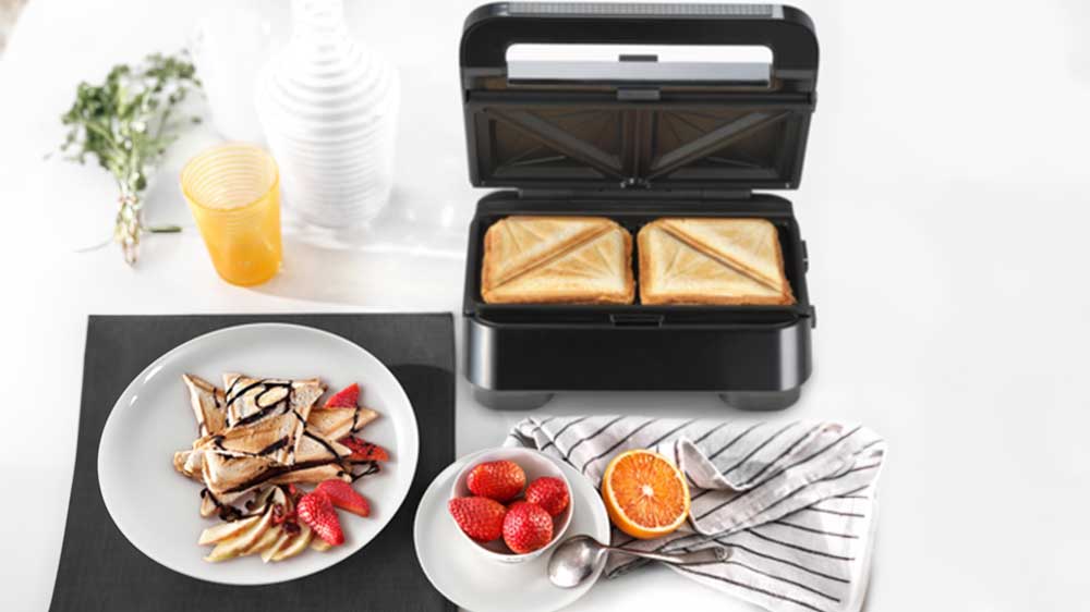 Prestrený stôl s otvoreným sendvičovačom, kde sú hotové dva toasty_02