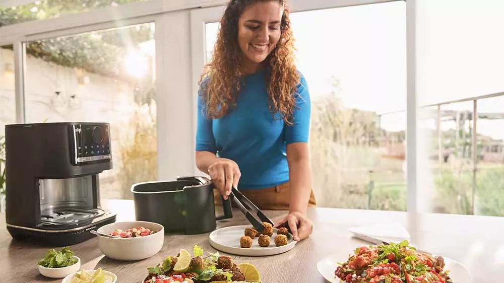 Žena pečie mäsové guličky v teplovzdušnej fritéze Braun 2v1 MultiFry 5 HF5050IBK_02
