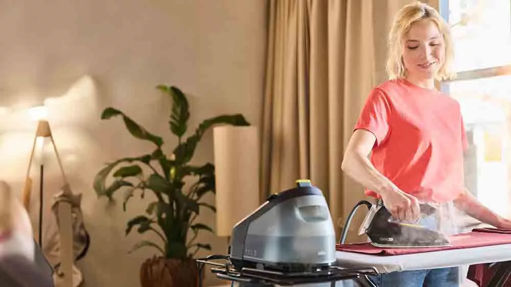 Žena žehlí pomocí parního generátoru Braun CareStyle 3 IS3257 BK na prkně