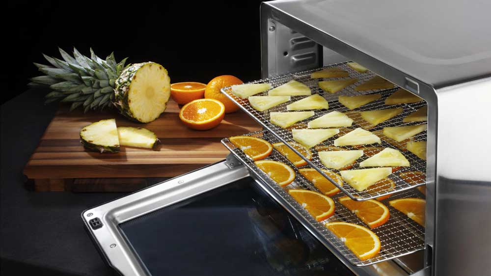 Nakrájený ananas a pomeranč na plátech sušičky_03