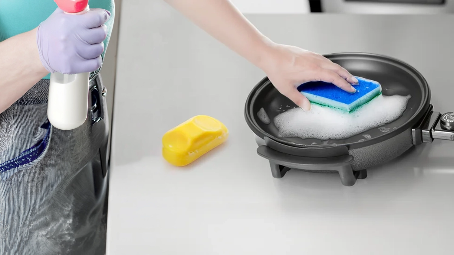 Ruka myje houbičkou elektrickou pánev Clatronic 3401