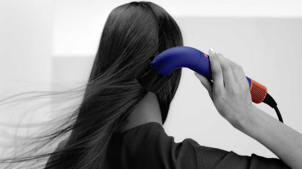 Žena používa sušič vlasov Dyson Supersonic r HD18 vinca blue/topaz_03