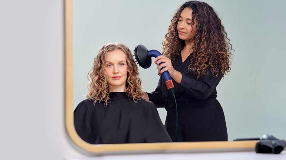 Kaderníčka upravuje žene vlasy fénom Dyson Supersonic r HD18 vinca blue/topaz s difuzérom_05