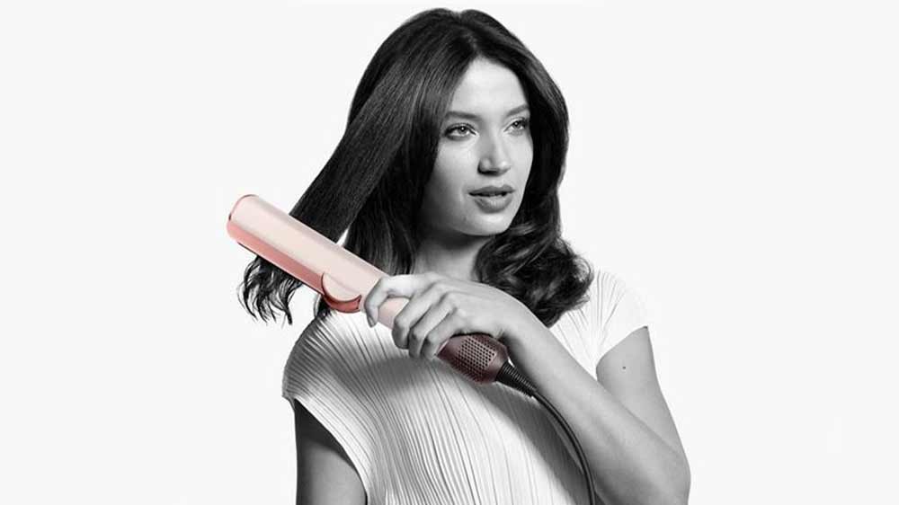 Žena si narovnáva vlasy žehličkou na vlasy Dyson Airstrait HT01 ceramic pink/rose gold_02