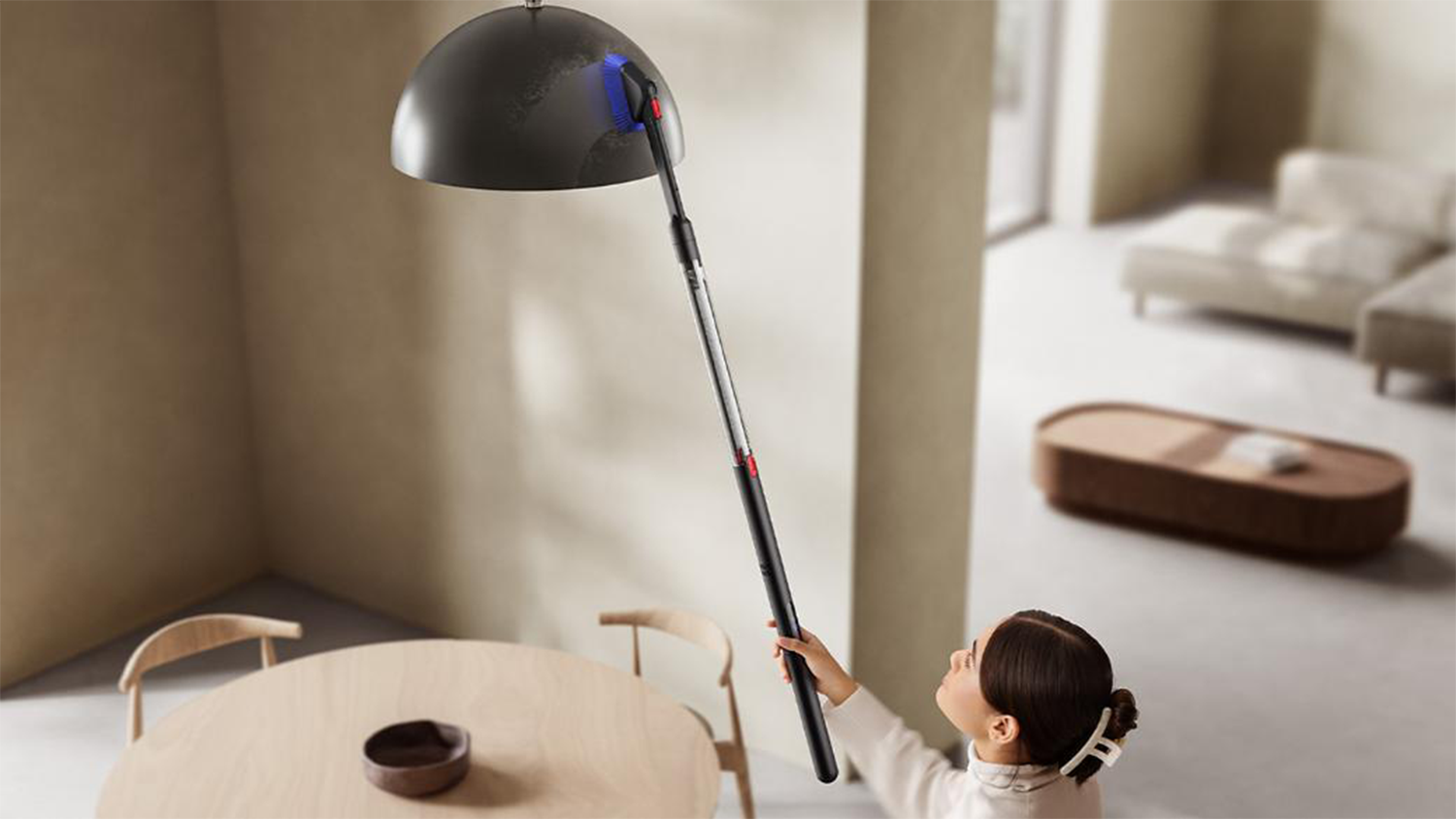 Žena čistí luster pomocou Dyson PencilVac Fluffycones