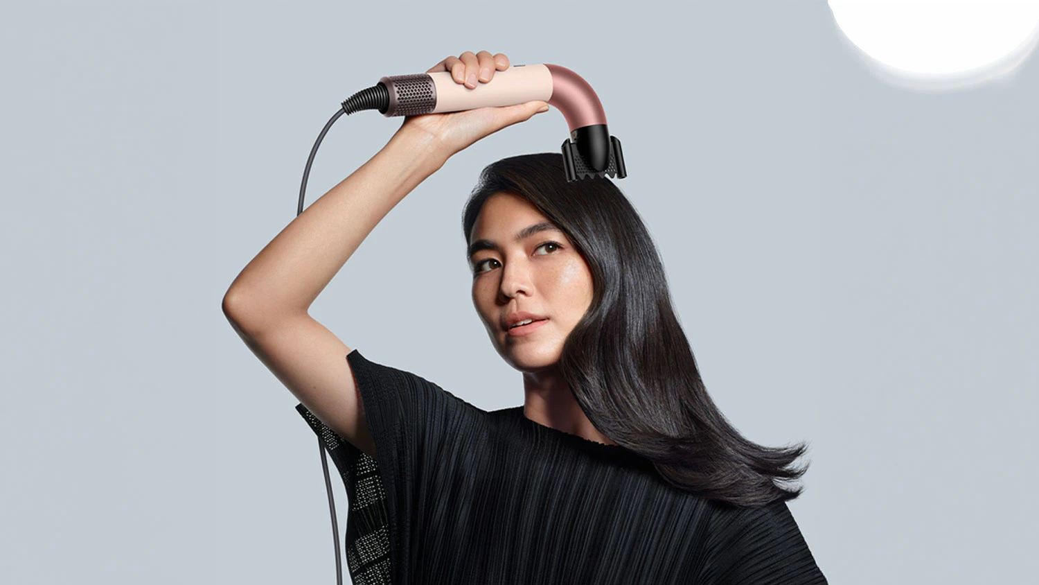 Žena si upravuje vlasy s Dyson Supersonic R HD17
