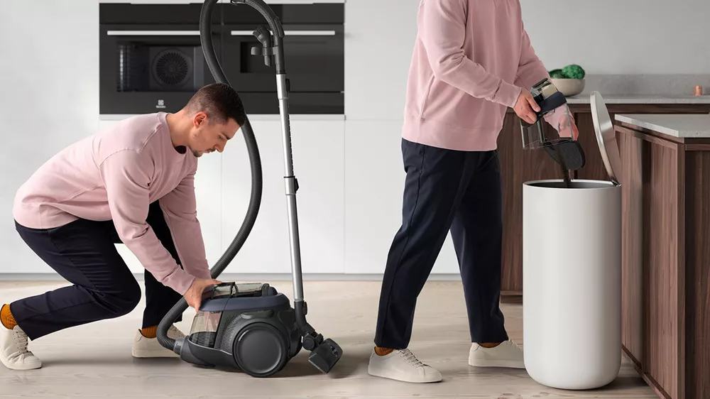 Muž vyndává nádobu z BEZSÁČKOVÉHO VYSAVAČE ELECTROLUX EL61C3DB_05