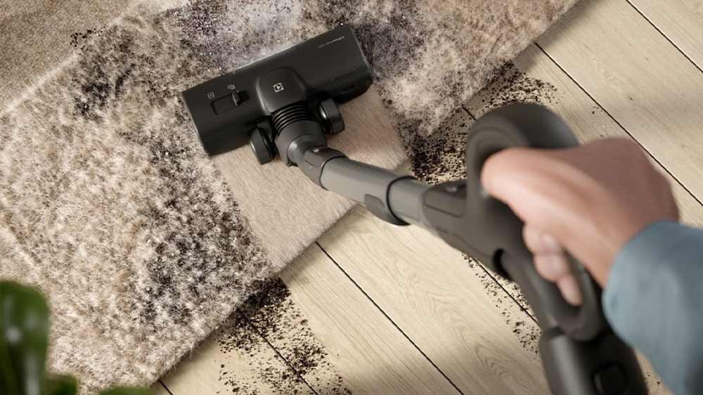 Člověk vysávající koberec i parkety s vysavačem Electrolux 800 EB81A3UG_02