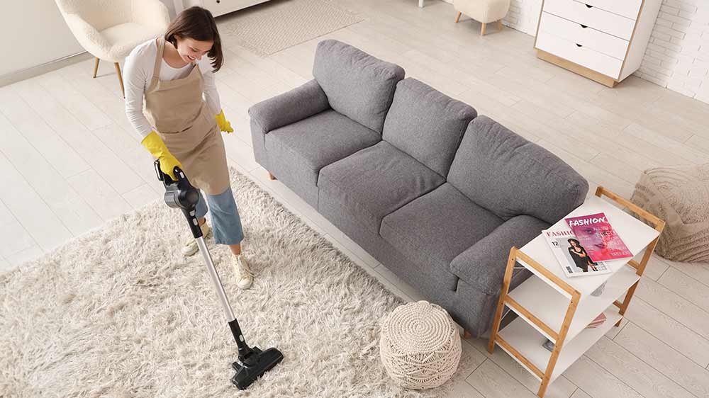 Žena vysávající koberec vysavačem Electrolux 600 EP61AB21UG_02