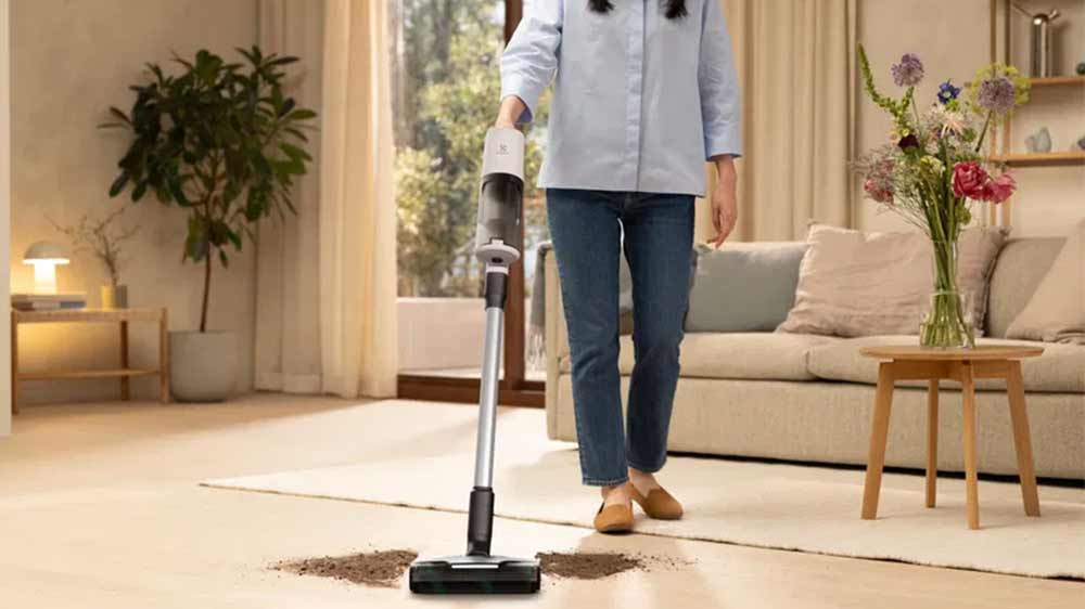 Žena používající vysavač Electrolux 600 EP61HB21UV k vyčištění nepořádku na podlaze_03