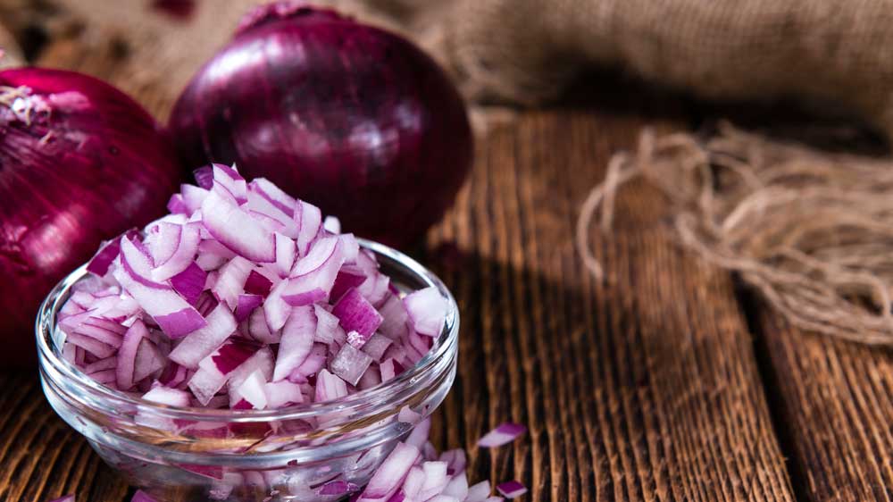 Červená cibule nasekaná v misce na stole_03