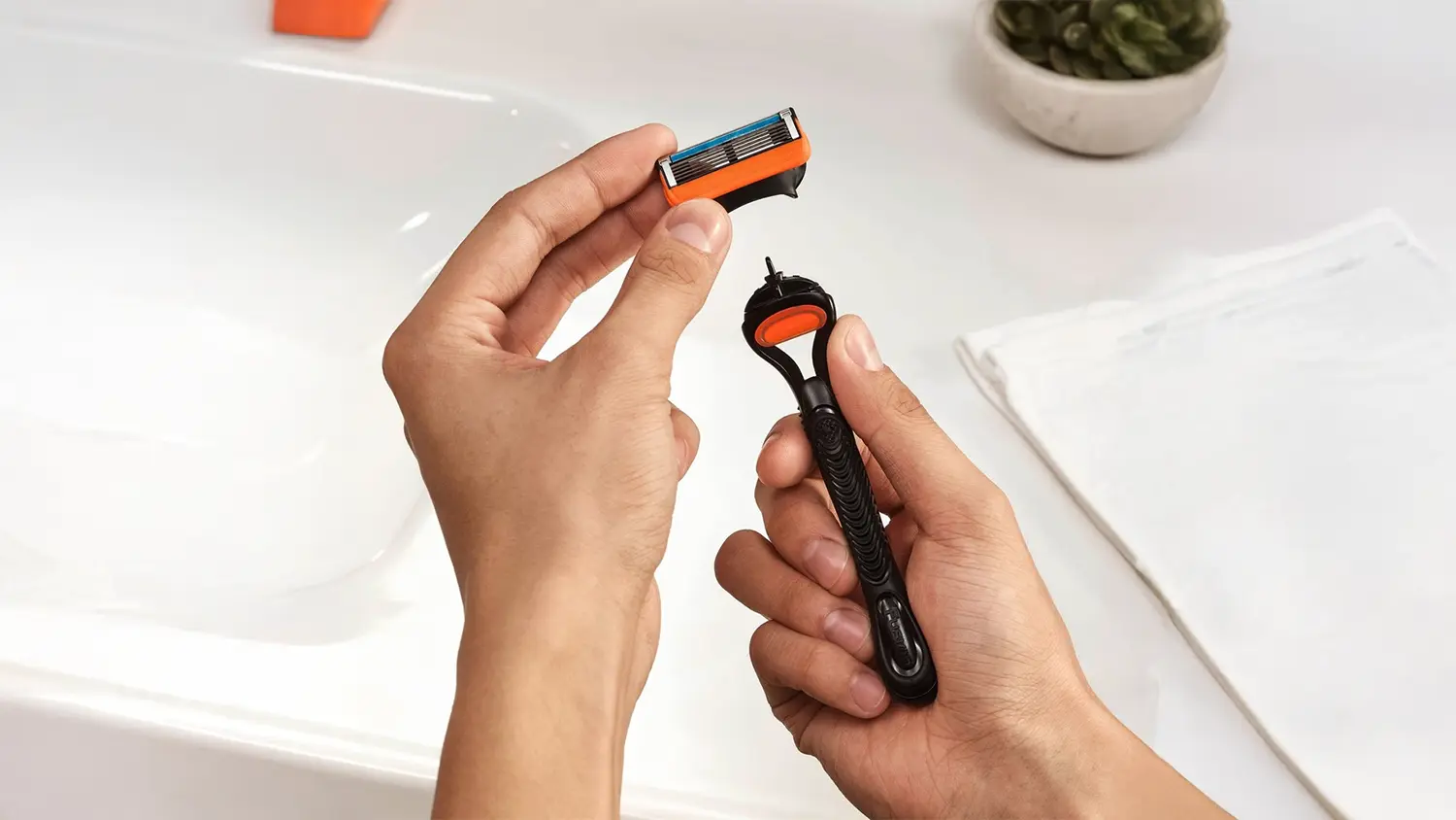 Ruce držící hlavici a Gillette Fusion5