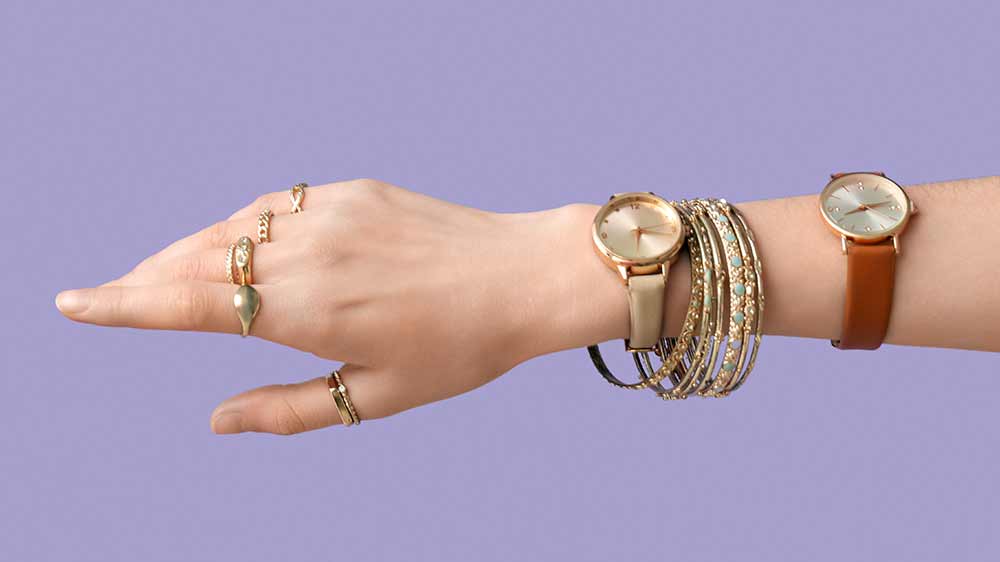Ženská ruka s mnoha prsteny, náramky a hodinkami_02