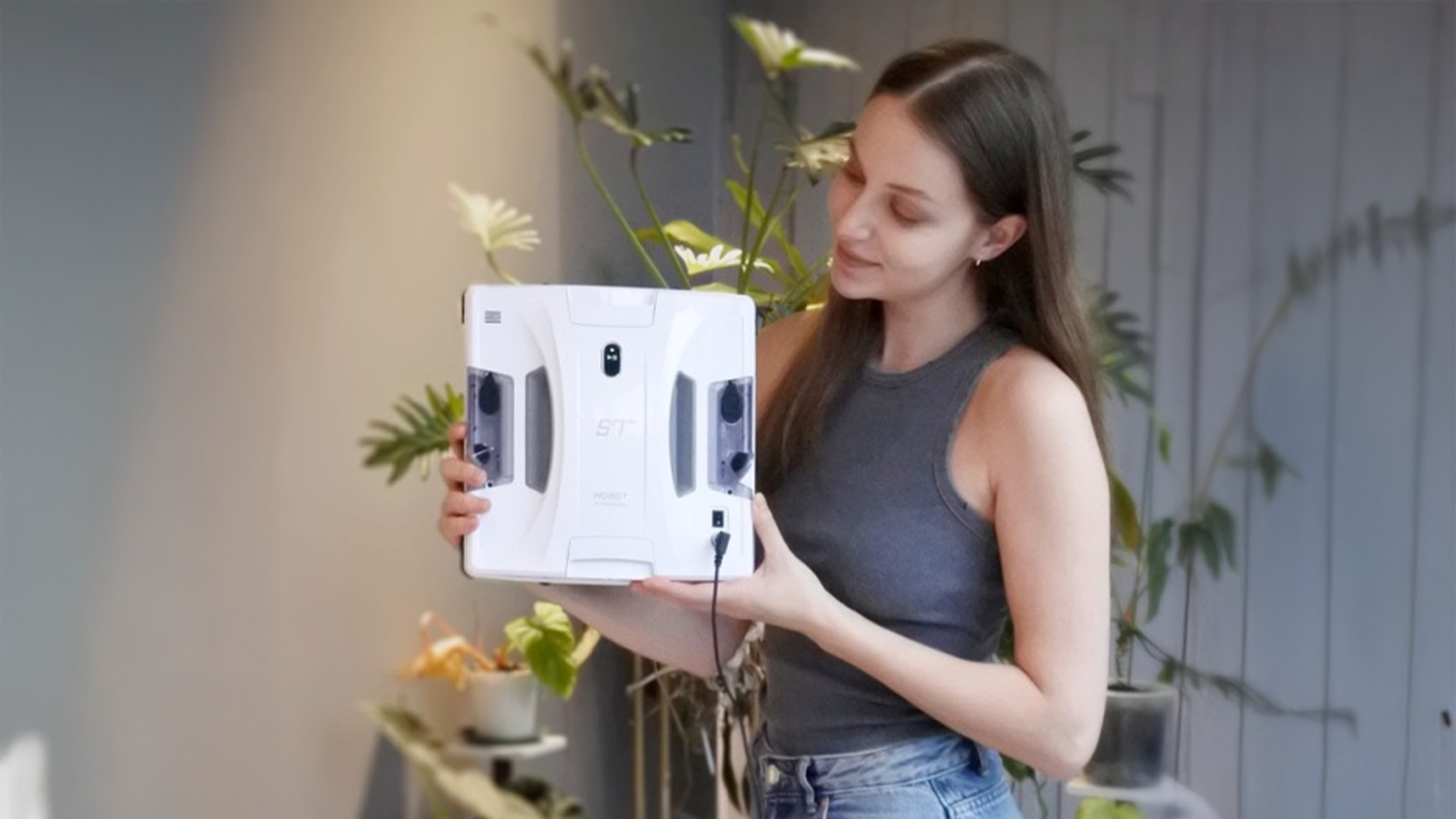 Žena drží robotický čistič oken HOBOT S7 PRO