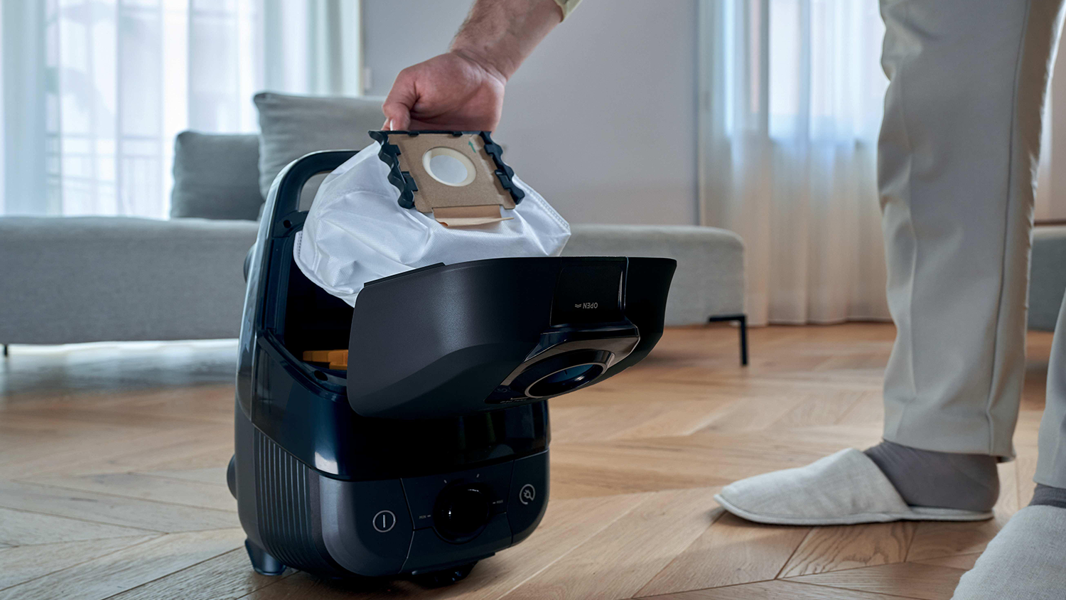Mužsk&aacute; ruka vyber&aacute; vrec&uacute;&scaron;ko Hoover H97 z vys&aacute;vača