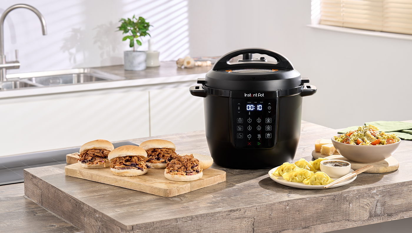 Instant Pot Classic 5,7 l postaven&yacute; na kuchyňsk&eacute; lince společně s j&iacute;dlem