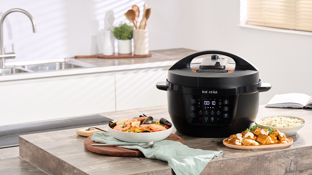 Instant Pot Classic XL postavený na kuchyňské lince s talíři s jídlem