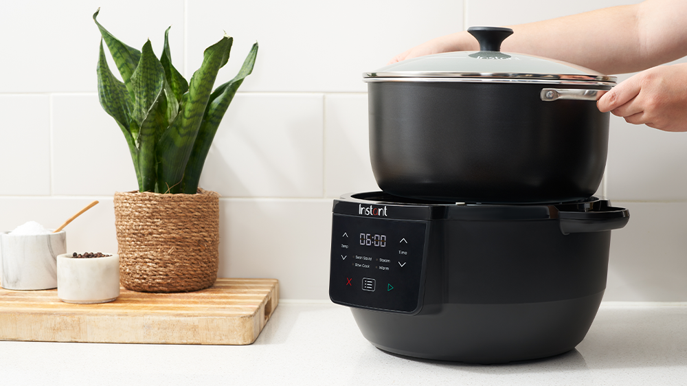 Osoba vkladá vnútornú nádobu do hrnca Instant Pot Superior Slow Cooker