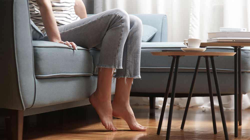 Žena sedí na pohovce, nohy na čisté zemi_03