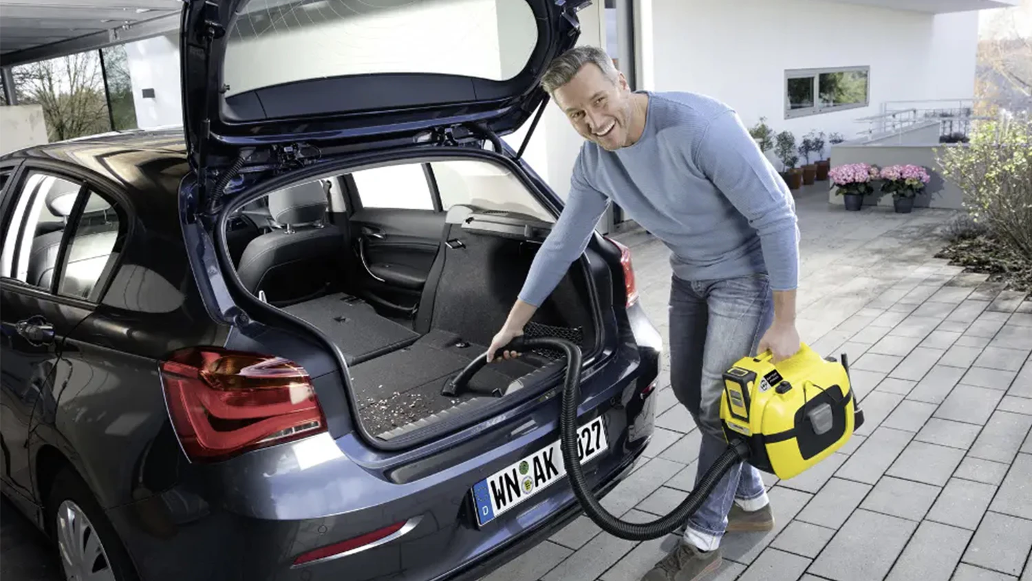 Muž uklízející auto s vysavačem Kärcher WD 1 Compact Battery