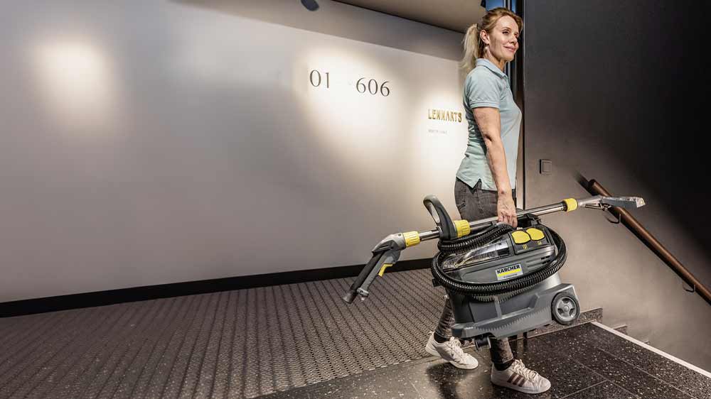 Žena nesoucí vysavač Kärcher Puzzi 8/1 Adv_02