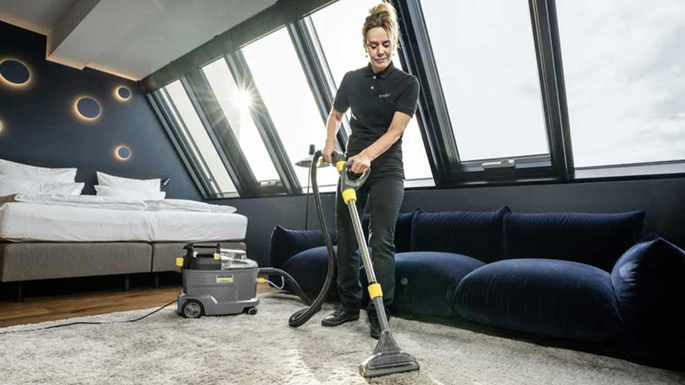 Žena čistí koberec s vysavačem Kärcher Puzzi 8/1 Adv_03