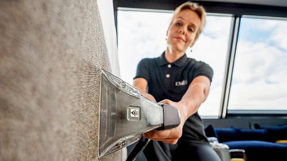 Žena čistící rám postele extra krátkou hubicí u vysavače Kärcher Puzzi 8/1 Adv_04