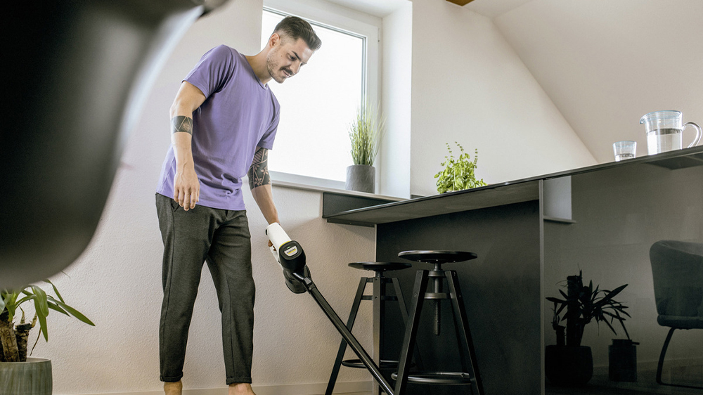 Muž vysává pokoj tyčovým vysavačem KARCHER VC 4 Cordless myHome_02
