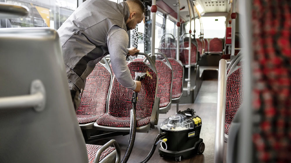 Muž čistící sedačky autobusu pomocí extraktoru KÄRCHER Puzzi 8/1 Anniversary Edition_04